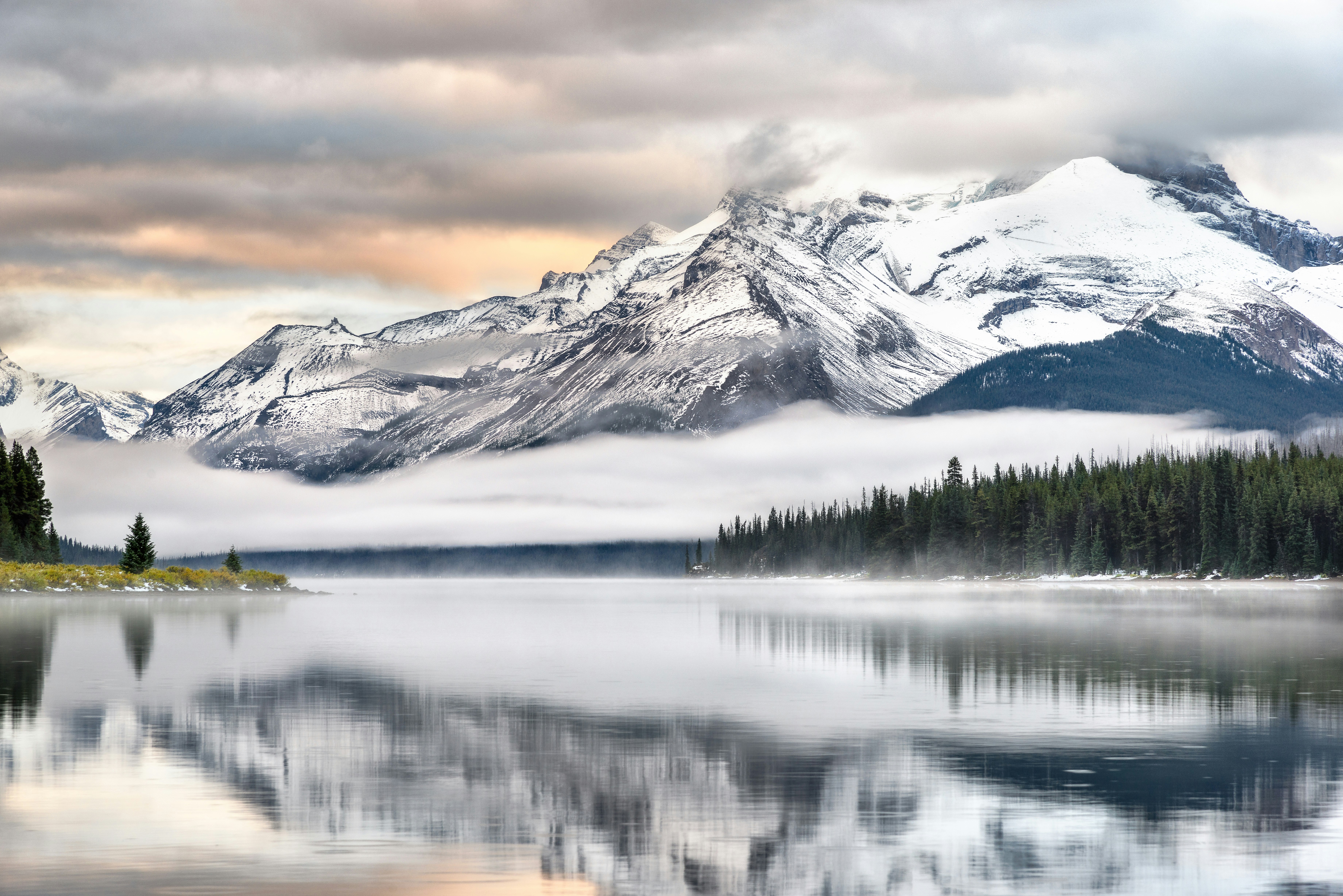 snow covered mountain near lake during daytime